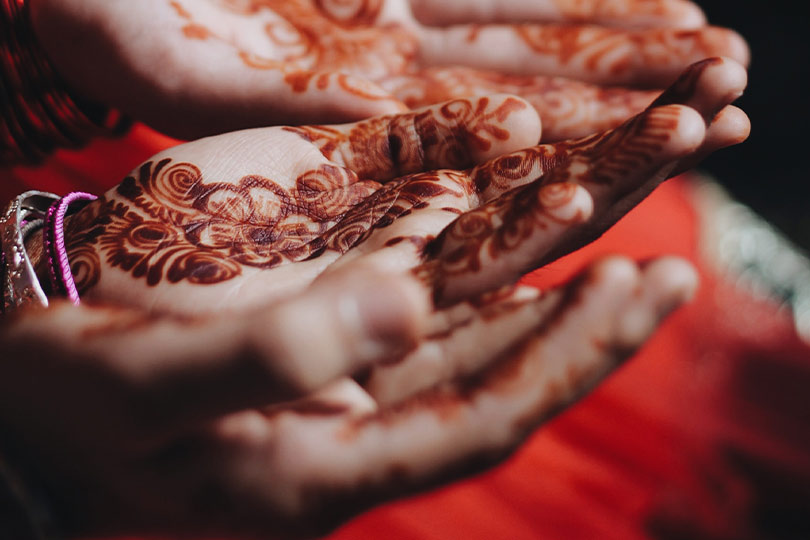 Women decorating their hand with Mehendi during Teej