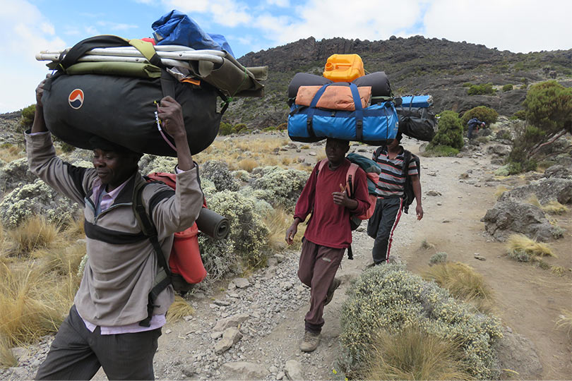 Porters carrying essential Kilimanjaro Climbing Gear during Mount Kilimanjaro Hike 